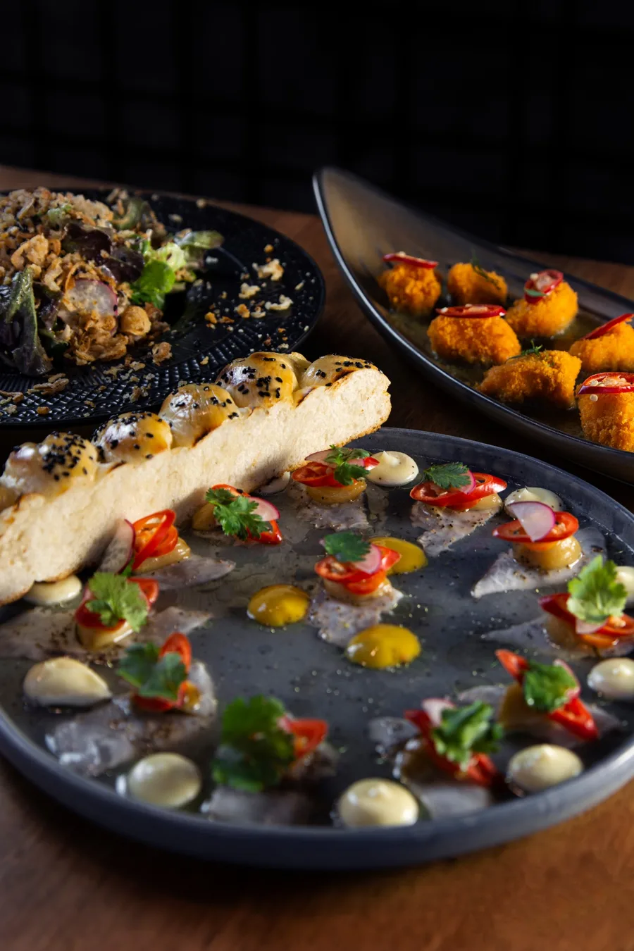 Fine dining plates photographed against a dark background.