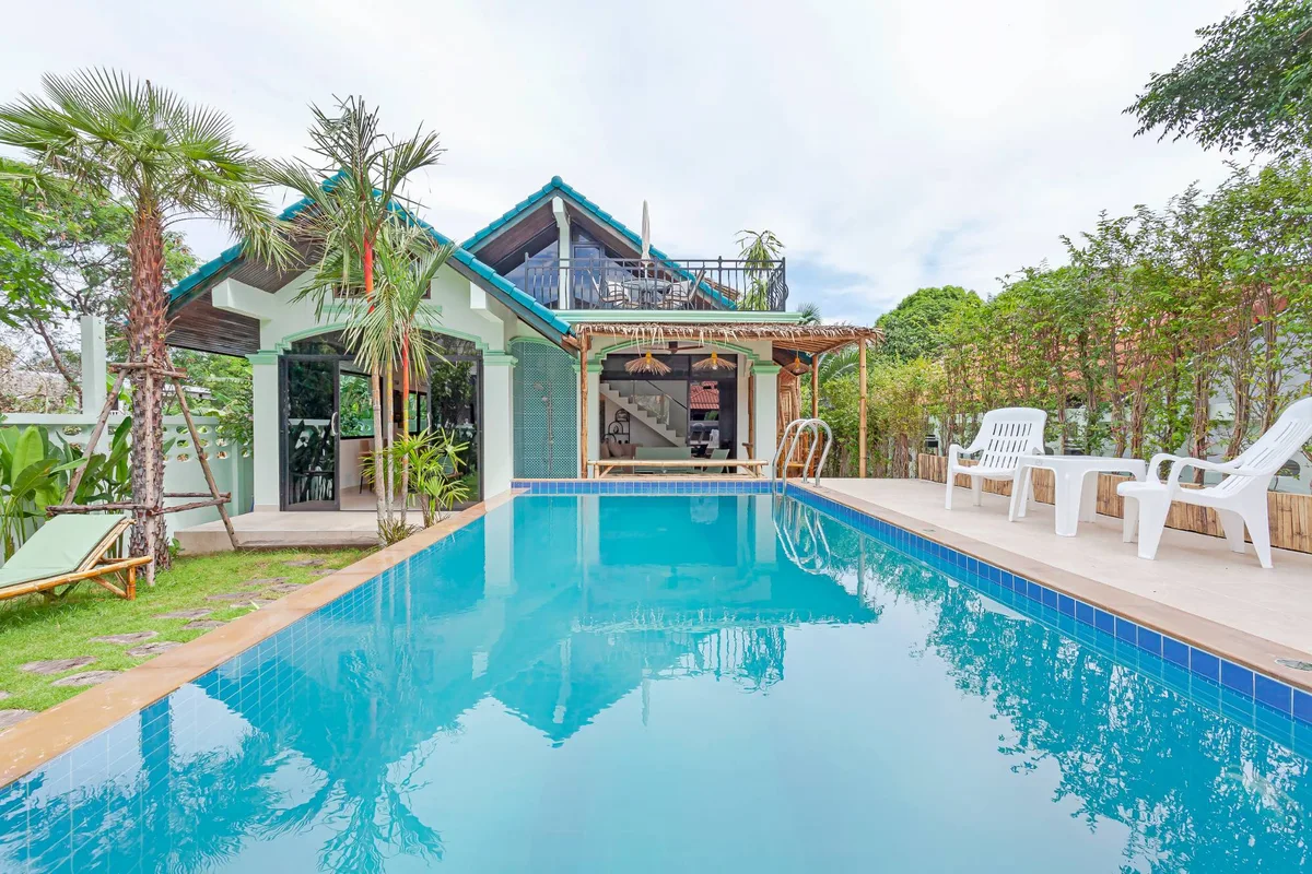 A garden villa and pool photographed from the poolside.